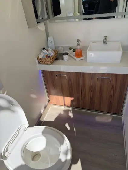 Restroom trailer vanity with vessel sink and amenities basket